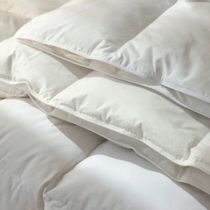 Nahaufnahme der Superior Daunendecke mit übereinanderliegenden, weich gefüllten Kammern und fein vernähter Baumwollhülle, zeigt die hochwertige Verarbeitung und das voluminöse Daunenfüllbild