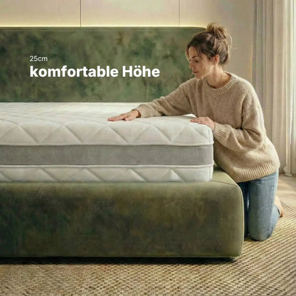 Person kniet neben der RIBECO 1000 Federkernmatratze und zeigt die komfortable Höhe von 25 cm