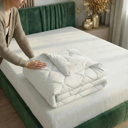 Person legt die Essential vegane Faserdecke zusammen und streicht die weich gesteppte Oberfläche glatt, leichte synthetische Füllung für pflegeleichten Schlafkomfort