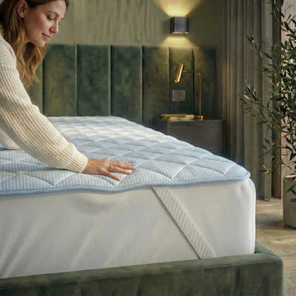 Hand drückt auf die TopCool Matratzenauflage auf dem Bett, gesteppte atmungsaktive Oberfläche zeigt weichen Liegekomfort und kühlende Materialstruktur