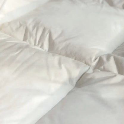 Nahaufnahme der Essential Federdecke mit weichem Bezug und locker gefüllten Kammern für luftigen Schlafkomfort und leichte Wärme