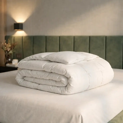 Zusammengelegte Premium Daunen- und Federdecke auf einem Bett, voluminöse Füllung für angenehme Wärme, hohen Schlafkomfort und luxuriöses Liegegefühl