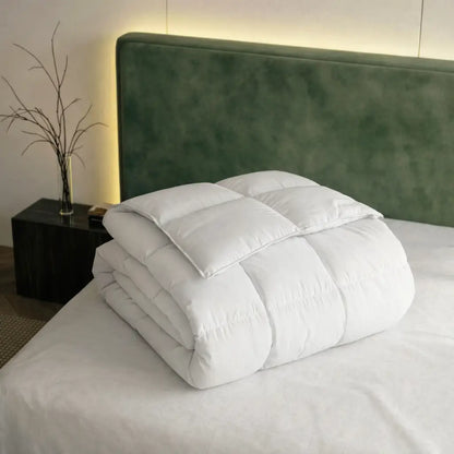 Weiße Superior Daunendecke gefaltet auf modernem Bett mit grünem Samt-Kopfteil, hochwertige Steppung für hohen Schlafkomfort