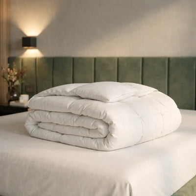 Zusammengelegte Premium Daunen- und Federdecke auf einem Bett, voluminöse Füllung für angenehme Wärme, hohen Schlafkomfort und luxuriöses Liegegefühl
