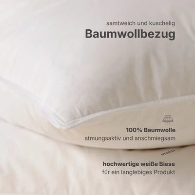 Detailansicht von zwei weißen Premium Feder- und Daunenkissen, übereinanderliegend mit sichtbaren Kissenkanten.