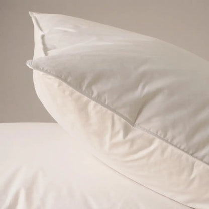 Detailansicht eines weißen Premium Feder- und Daunenkissens mit sichtbarer Kissenkante und Bezug.