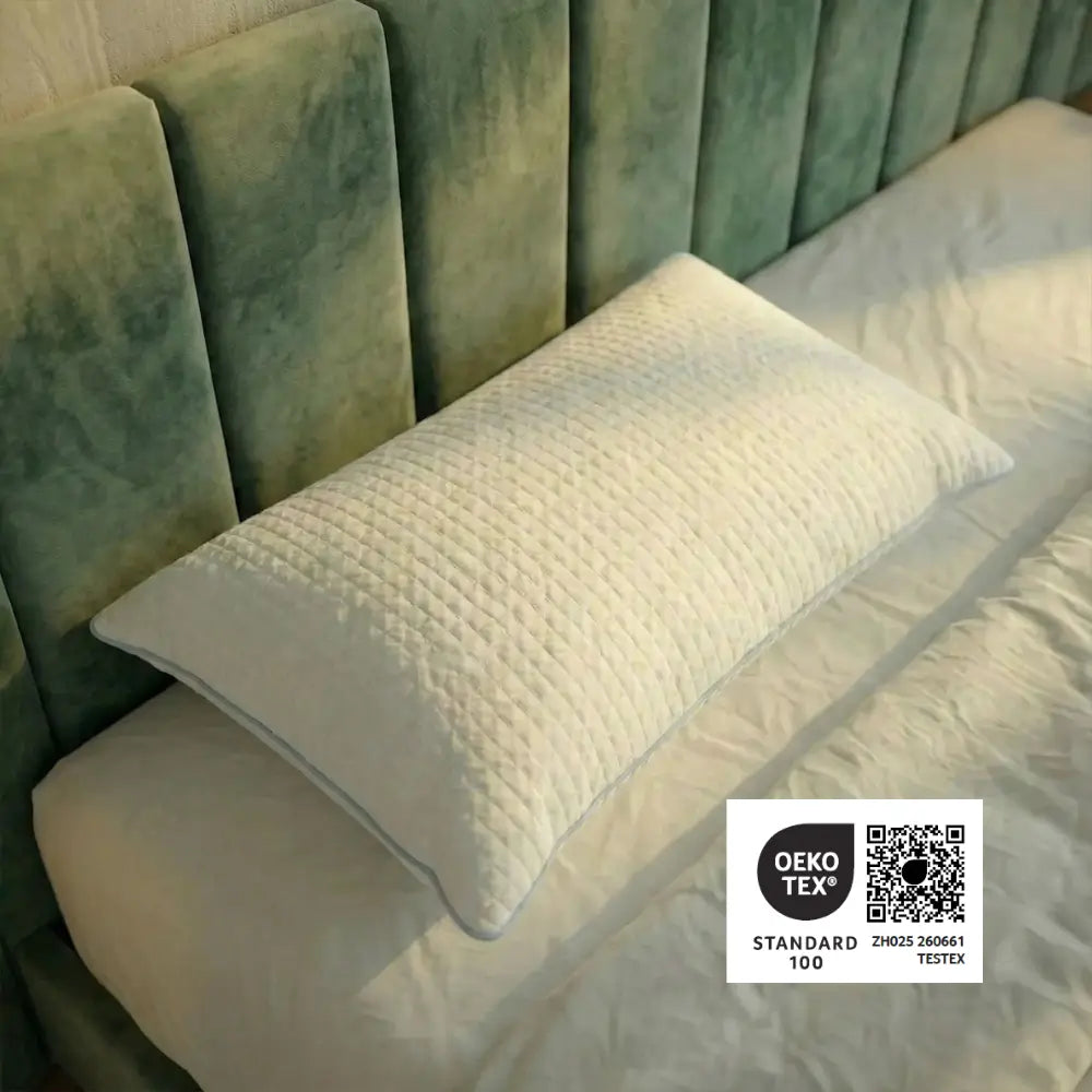 Weißes Essential Kühlkissen mit strukturierter Oberfläche auf einem Bett, dargestellt mit OEKO-TEX Standard 100 Siegel