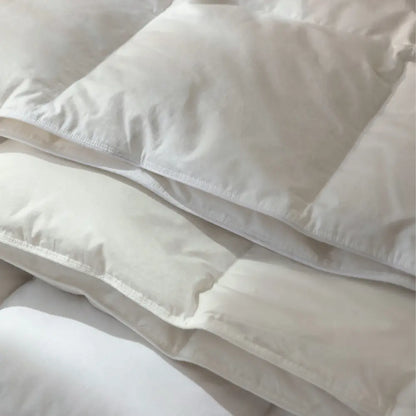 Detailaufnahme der weißen Premium veganen Decke Polypearls mit übereinanderliegenden, weich gepolsterten Steppkammern und sauber verarbeiteten Nähten