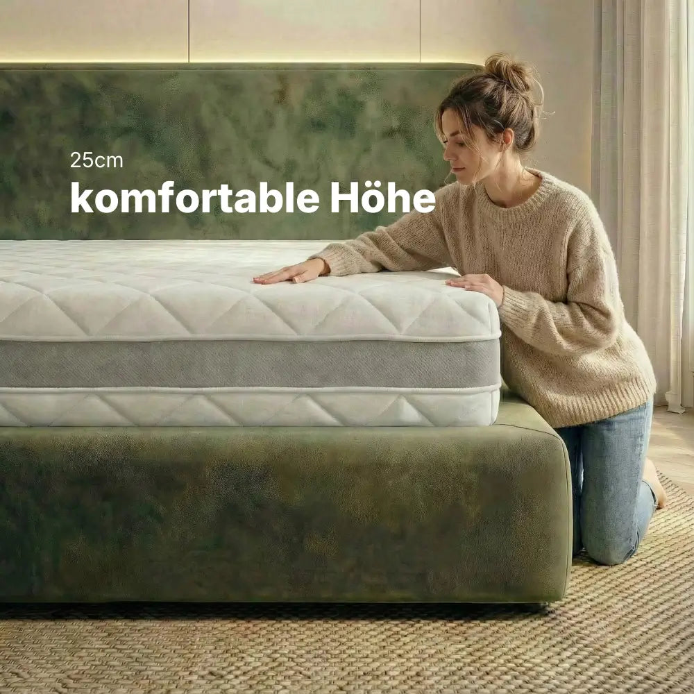 Person kniet neben der RIBECO 1000 Federkernmatratze und zeigt die komfortable Höhe von 25 cm